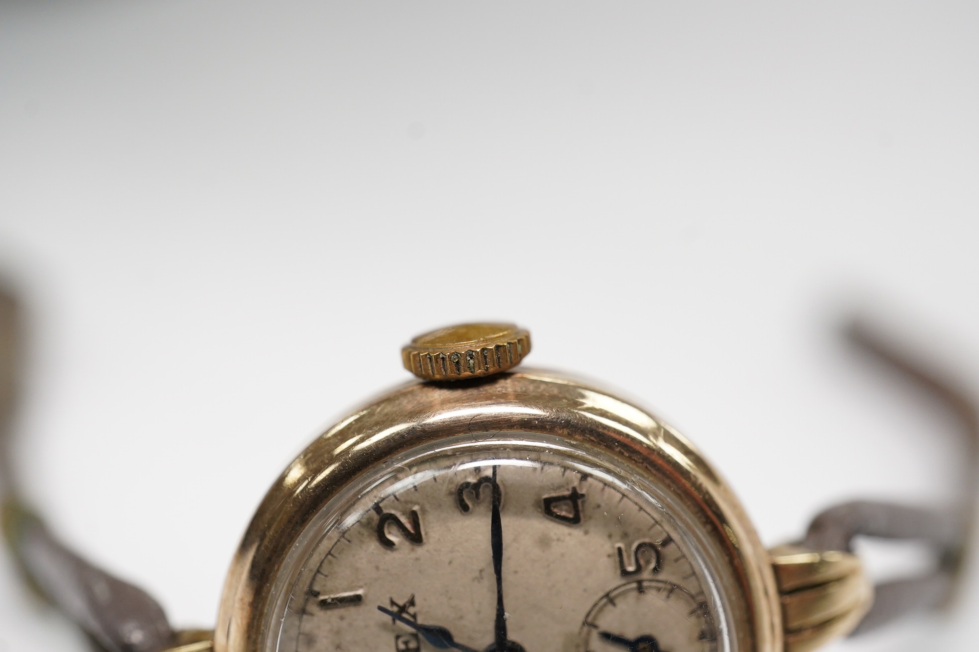 A lady's 9ct gold Rolex manual wind wrist watch, with Arabic dial and subsidiary seconds, case back numbered 22110, case diameter 21mm, on an associated twin strand fabric strap. Condition - poor to fair